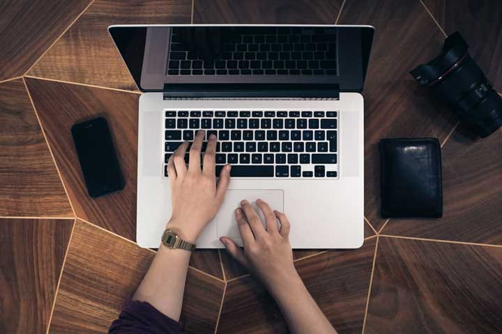 Person typing on a laptop — website essential pages hero